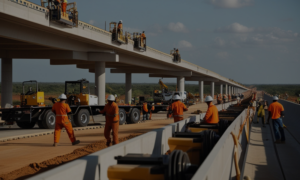 A hyper-realistic photojournalistic image showing a large-scale infrastructure project in Africa, such as the construction of a modern road or bridge